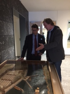 Wethouder Robert te Beest krijgt uitleg van Tom Hazenberg bij de maquette van fort Velsen 1 bij de rondleiding over tentoonstelling Romeinse Kust in het Huis van Hilde. 